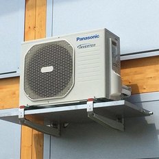 Eine Panasonic Klimaanlage mit Inverter-Technologie, montiert an einer Wand aus Holz und Metall.